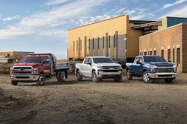 linesup of Chevrolet work trucks on a construction site