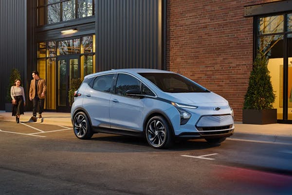 chevrolet vehicle parked on road with couple approaching