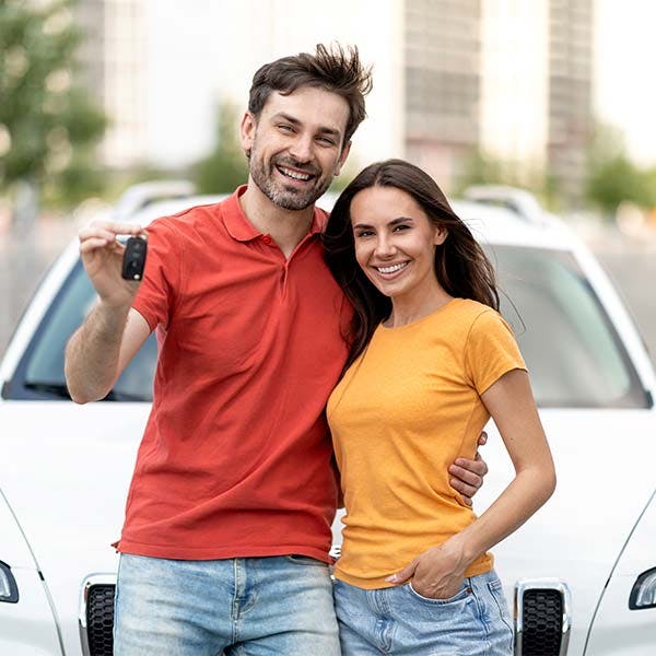 couple standing in front of a car