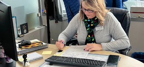woman sitting in front of a computer offering car financing options