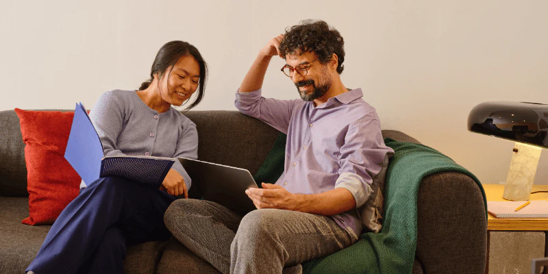 Couple sitting on a couch together looking at Ford financing options