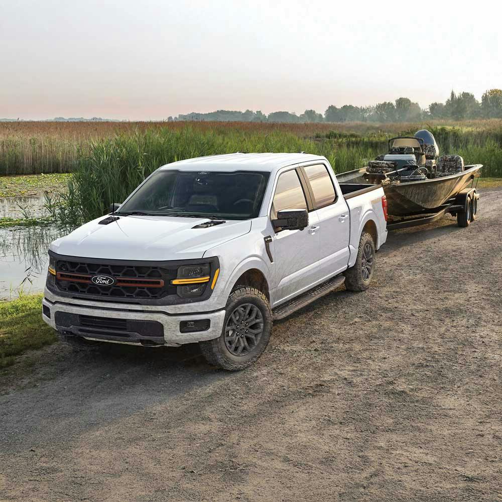 a white ford f-150 towing a boat