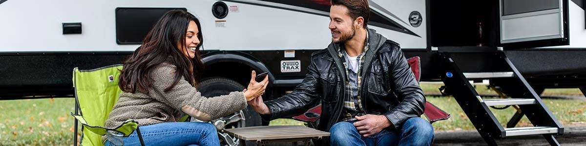 young couple sitting by rv