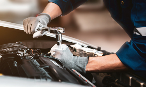 mechanic servicing under the hood of a vehicle