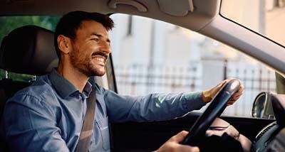 a man driving his newly purchased pre-owned vehicle