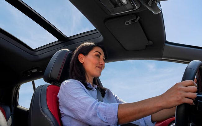 happy woman driving her chevy vehicle