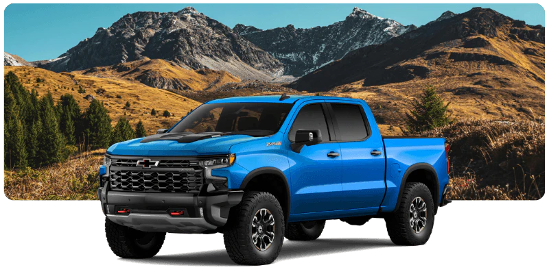 Blue Chevrolet Silverado truck for sale parked against a mountain landscape