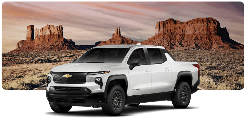 White Chevrolet Silverado EV truck for sale in a desert landscape with red rock formations